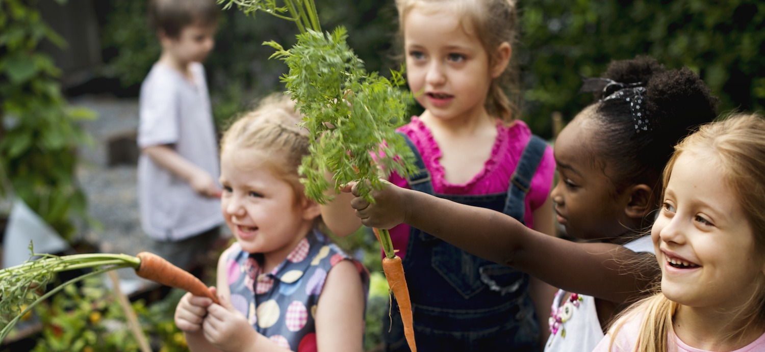 Young girls holding carrots.