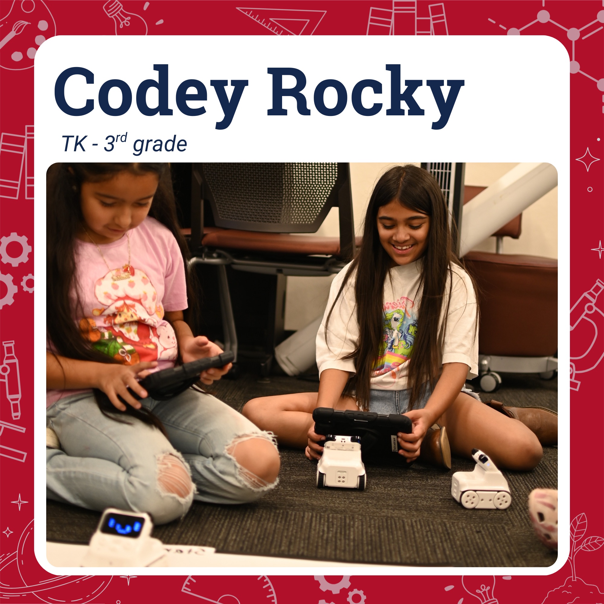 Two students sitting on carpeted floor playing with ipads and several Codey Rocky robots