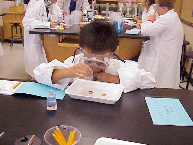 Student at a science lab station with goggles