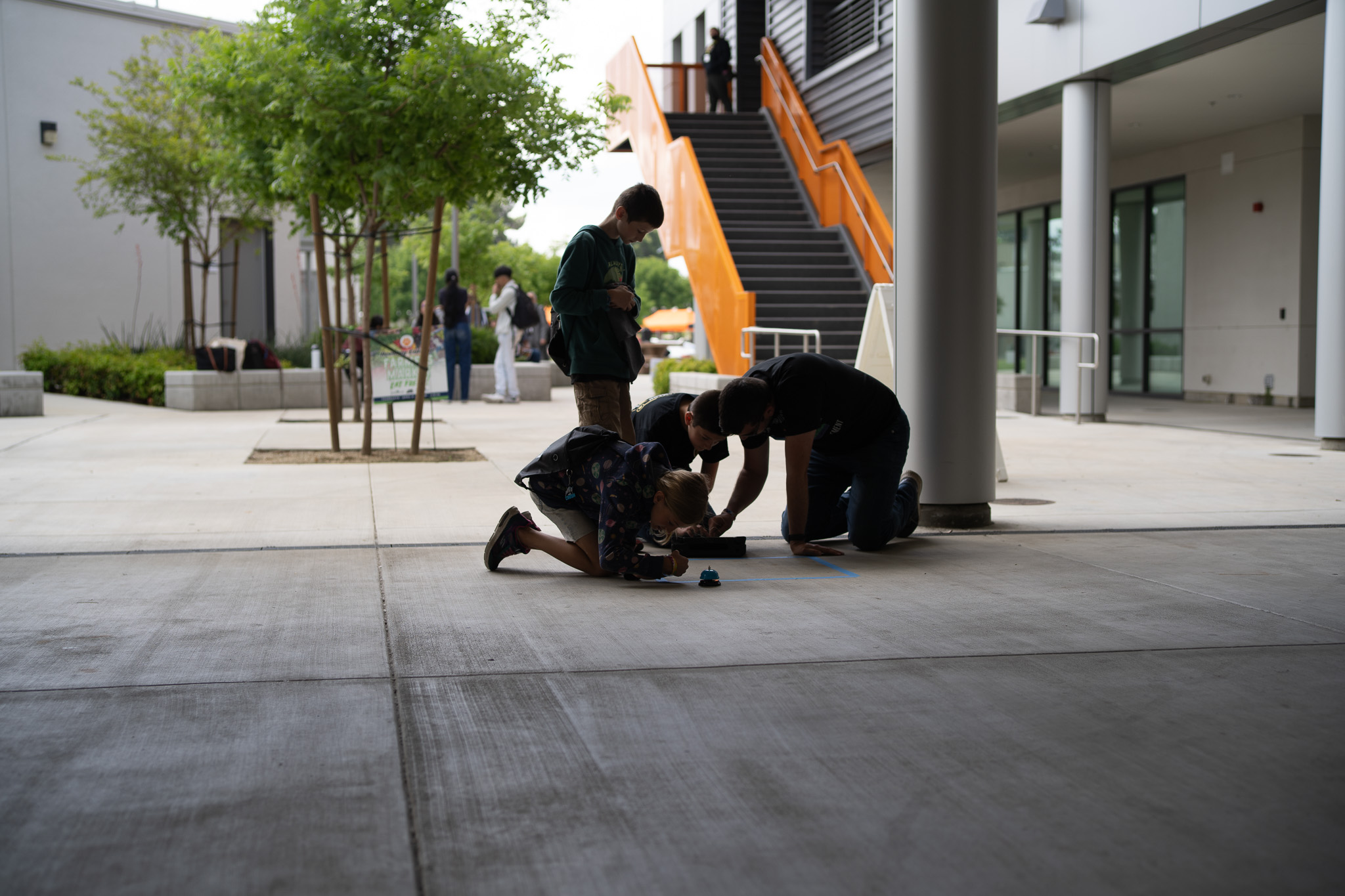 Students coding beneath staircase