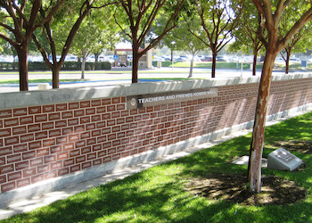 Brick wall surrounded by grass and trees