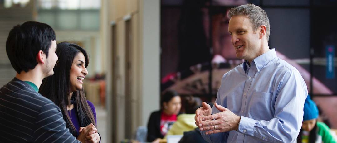 Teacher speaking to two students.